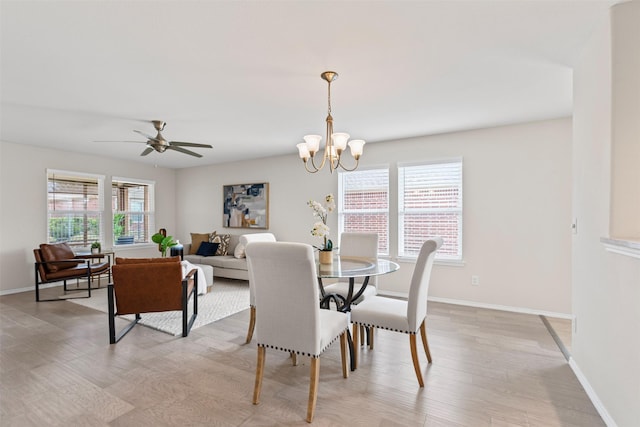 dining area featuring ceiling fan with notable chandelier and light hardwood / wood-style flooring