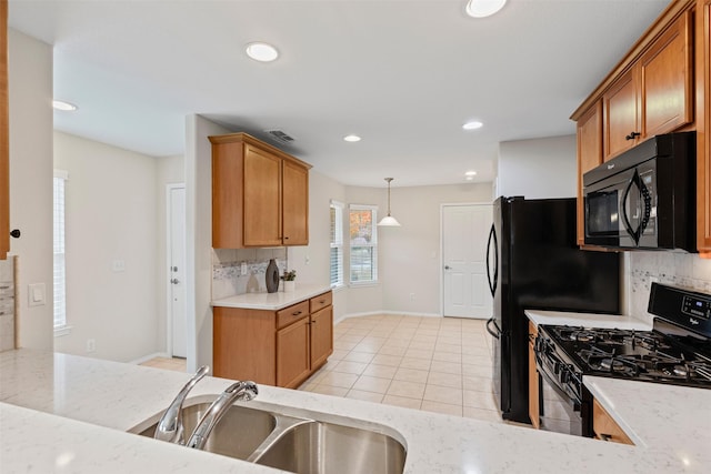 kitchen featuring decorative light fixtures, sink, backsplash, light tile patterned floors, and black appliances