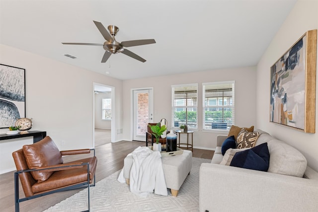 living room featuring ceiling fan, hardwood / wood-style floors, and a wealth of natural light