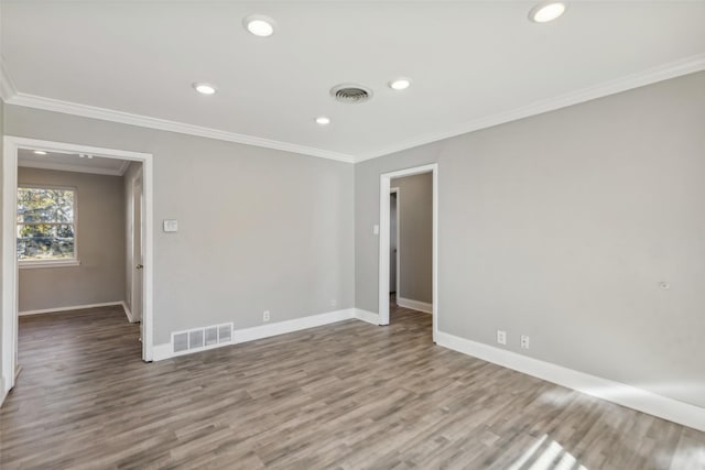 spare room with hardwood / wood-style flooring and crown molding