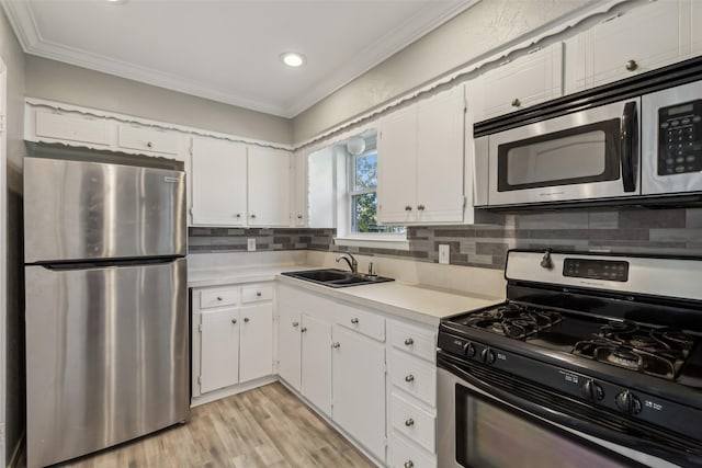 kitchen featuring white cabinetry, ornamental molding, stainless steel appliances, and sink