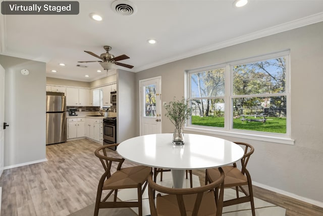 dining room with ceiling fan, ornamental molding, sink, and light hardwood / wood-style flooring