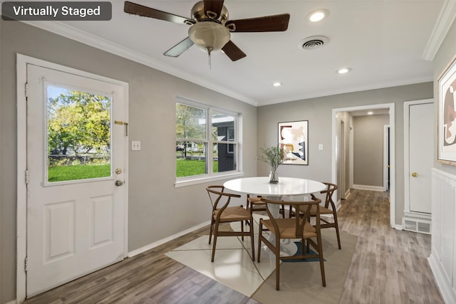 dining space with hardwood / wood-style flooring and ornamental molding