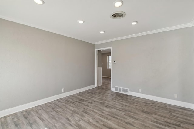 empty room with hardwood / wood-style floors and ornamental molding