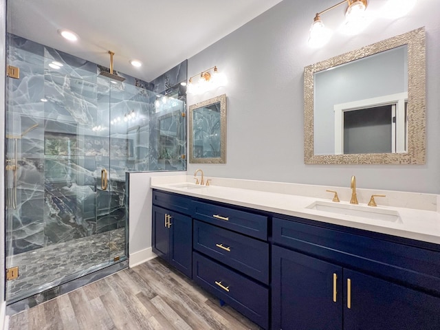 bathroom with hardwood / wood-style floors, vanity, and a shower with door