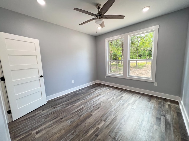 spare room featuring dark hardwood / wood-style floors and ceiling fan