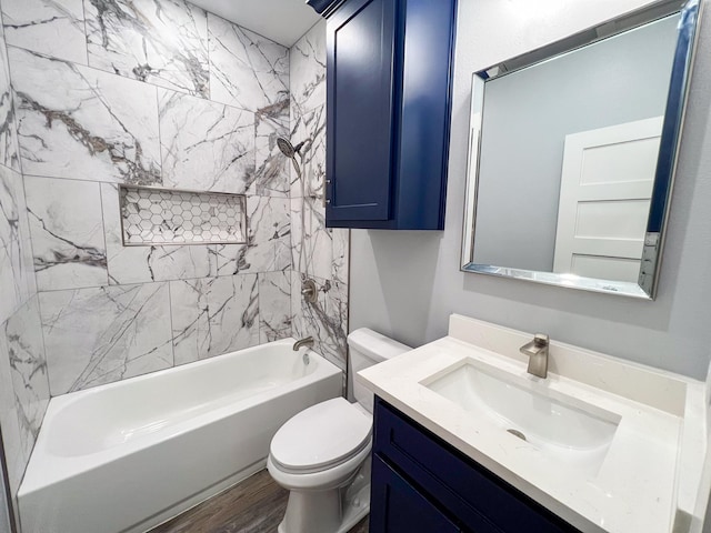 full bathroom featuring hardwood / wood-style floors, vanity, toilet, and tiled shower / bath