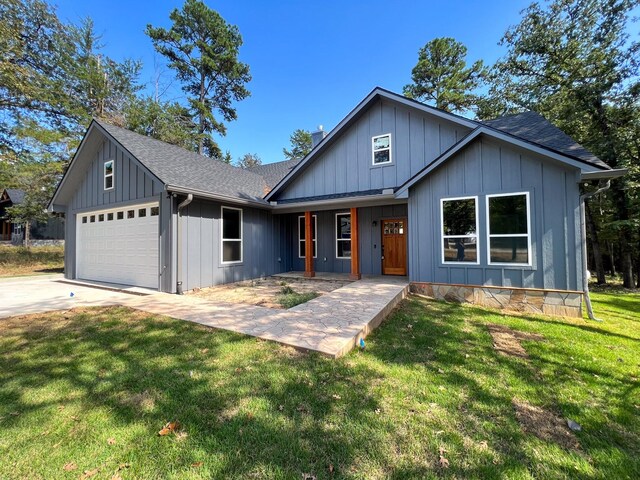 view of front of property with a front yard, a porch, and a garage