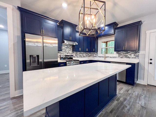 kitchen featuring pendant lighting, a center island, stainless steel appliances, and hardwood / wood-style floors