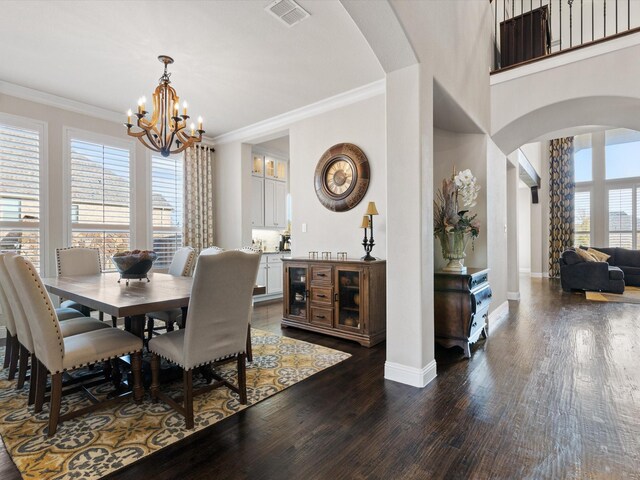 dining area featuring a chandelier, crown molding, and dark wood-type flooring