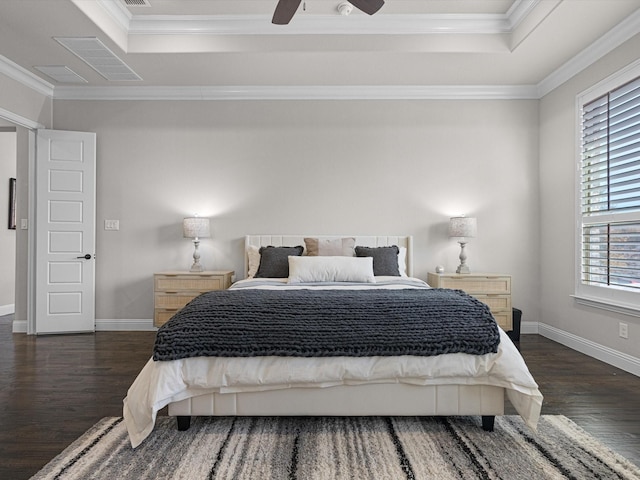 bedroom featuring dark wood-type flooring, a raised ceiling, ceiling fan, and ornamental molding