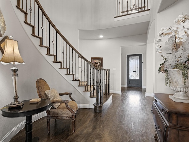 foyer entrance with dark wood-type flooring and a high ceiling