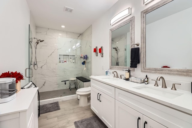 bathroom featuring toilet, vanity, a shower with shower door, and hardwood / wood-style flooring