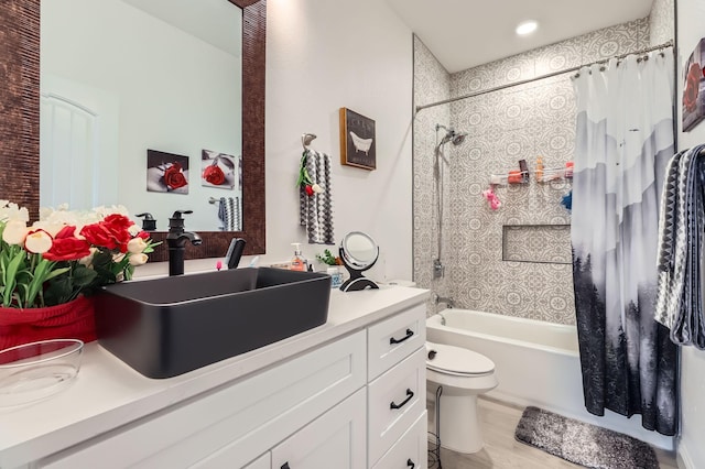 full bathroom with hardwood / wood-style floors, vanity, shower / tub combo, and toilet