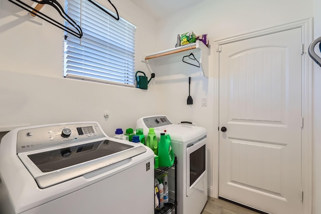 washroom with washing machine and clothes dryer and light hardwood / wood-style floors