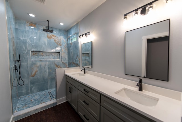 bathroom featuring a tile shower, vanity, and hardwood / wood-style flooring