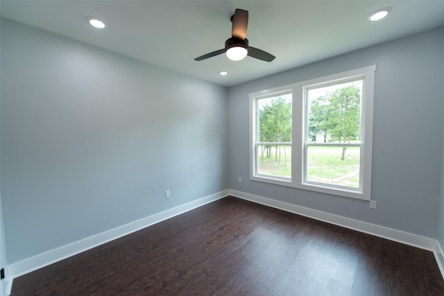 empty room with ceiling fan and dark wood-type flooring