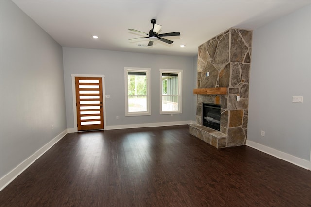 unfurnished living room featuring a fireplace, ceiling fan, and dark hardwood / wood-style flooring