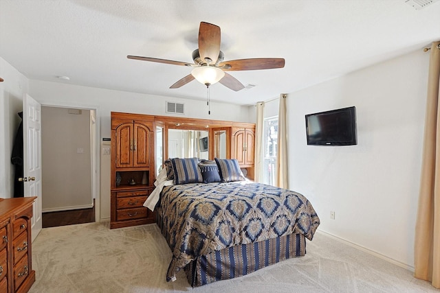 bedroom with light colored carpet and ceiling fan