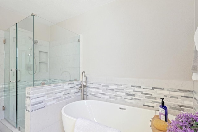 bathroom featuring separate shower and tub and tile walls