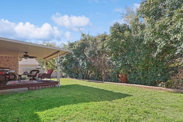 view of yard featuring ceiling fan and a wooden deck