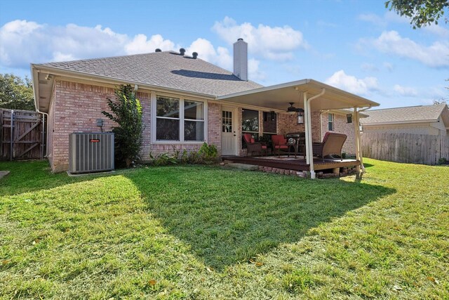 back of house featuring central AC, ceiling fan, a yard, and a deck