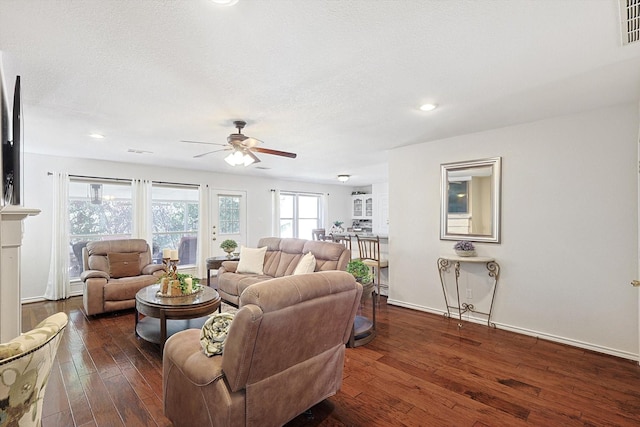 living room featuring a textured ceiling, dark hardwood / wood-style floors, and ceiling fan