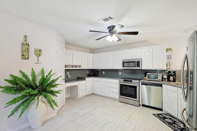 kitchen with backsplash, white cabinetry, ceiling fan, and stainless steel appliances