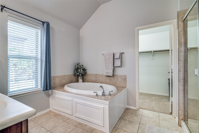 bathroom featuring tile patterned flooring, vaulted ceiling, and a healthy amount of sunlight