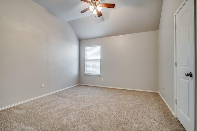 spare room with ceiling fan, light colored carpet, and vaulted ceiling