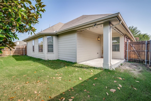 back of house with a yard and a patio