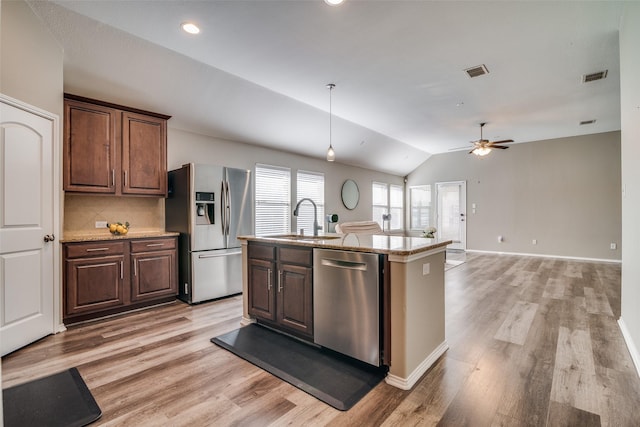 kitchen with lofted ceiling, ceiling fan, an island with sink, light hardwood / wood-style floors, and stainless steel appliances