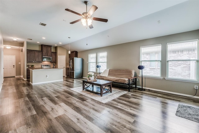 living room with ceiling fan, lofted ceiling, and dark wood-type flooring