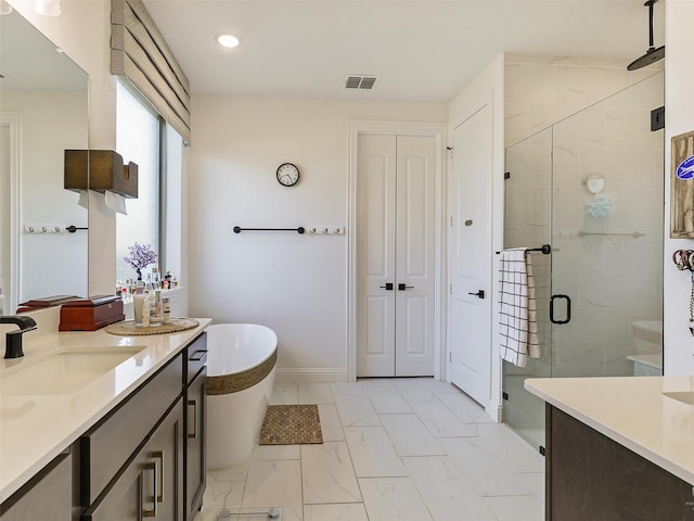 bathroom with vanity and shower with separate bathtub