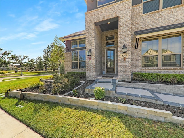 view of exterior entry featuring a yard