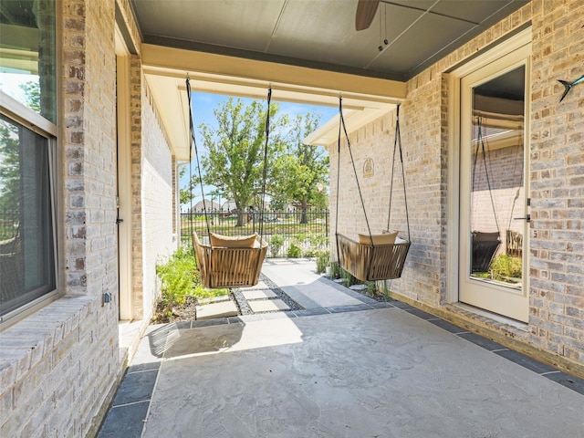 unfurnished sunroom with ceiling fan