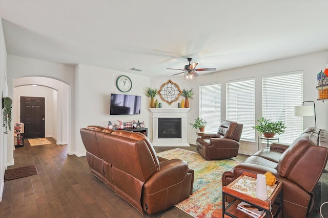 2133 Miramar Dr, Little Elm, TX 75068 - living room featuring arched walkways, ceiling fan, dark wood-type flooring, and a glass covered fireplace