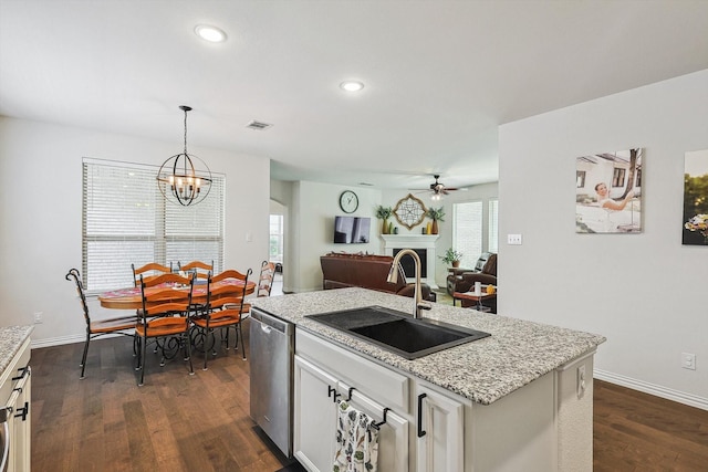 kitchen with sink, decorative light fixtures, dishwasher, dark hardwood / wood-style floors, and an island with sink