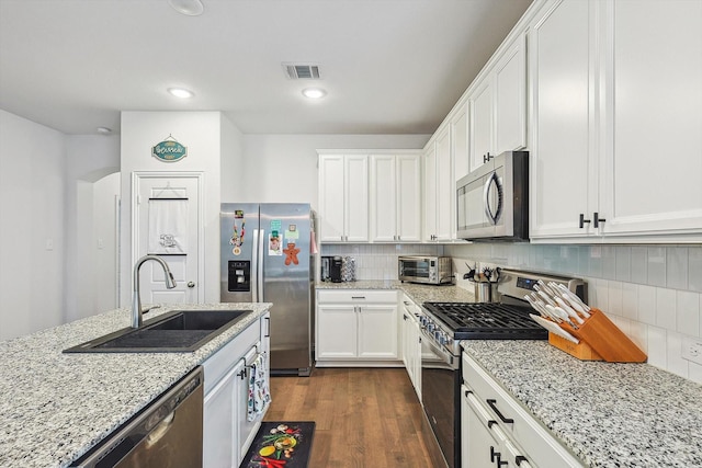 kitchen with dark hardwood / wood-style flooring, white cabinetry, sink, and appliances with stainless steel finishes