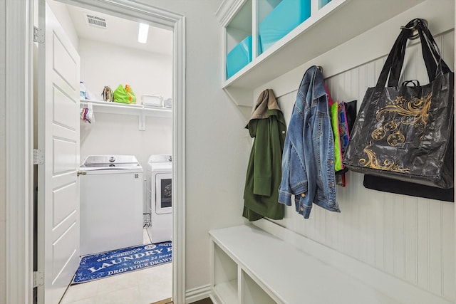 mudroom with washer and dryer and light tile patterned floors