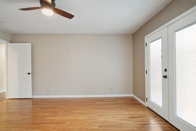 unfurnished room featuring ceiling fan, french doors, a textured ceiling, and light wood-type flooring