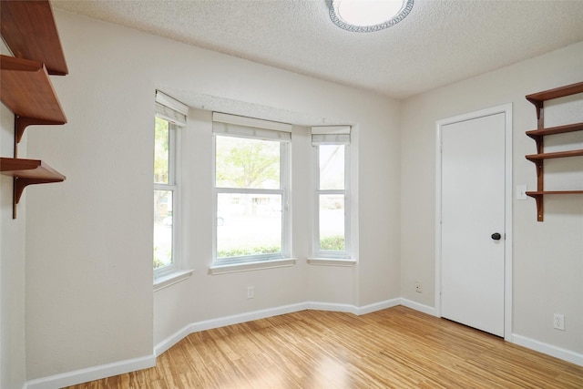 empty room featuring light hardwood / wood-style flooring and a textured ceiling