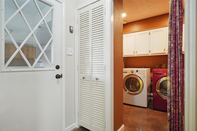 clothes washing area featuring cabinets and washer and clothes dryer