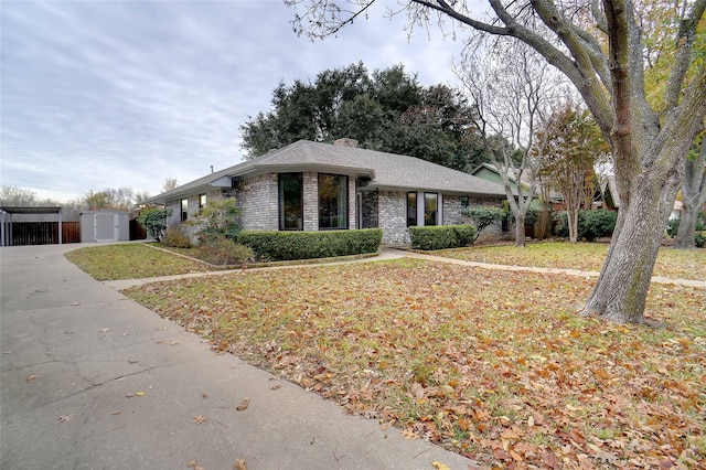 view of front facade with a shed and a front yard