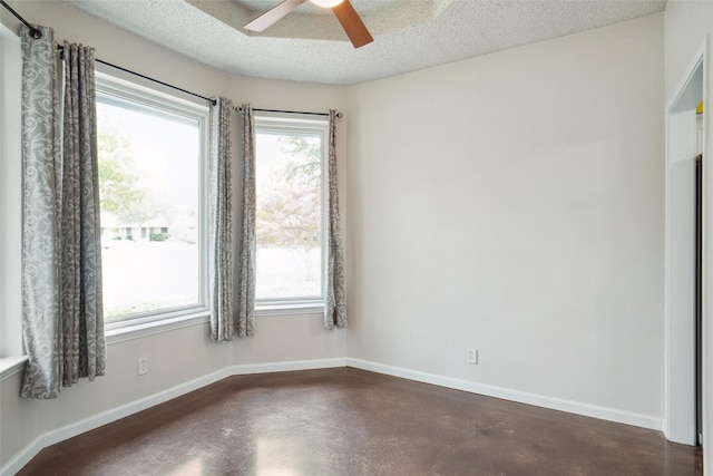 spare room featuring ceiling fan, plenty of natural light, and a textured ceiling