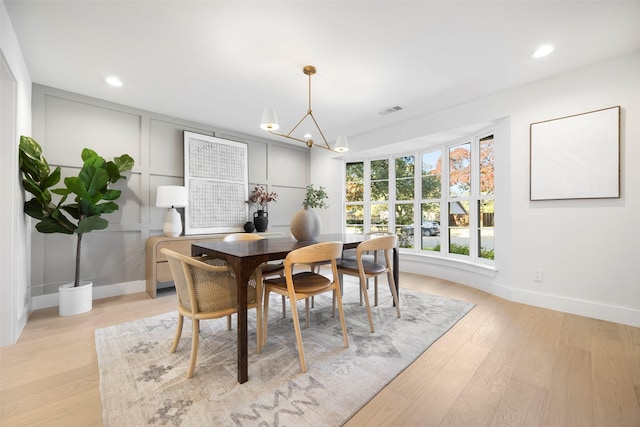 dining room with a chandelier and light wood-type flooring