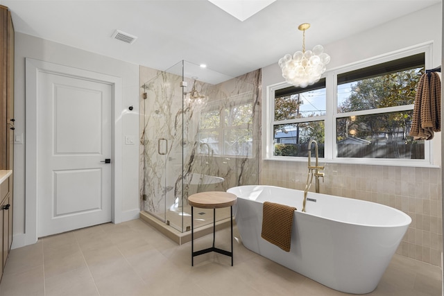 bathroom with vanity, tile walls, independent shower and bath, a chandelier, and tile patterned flooring