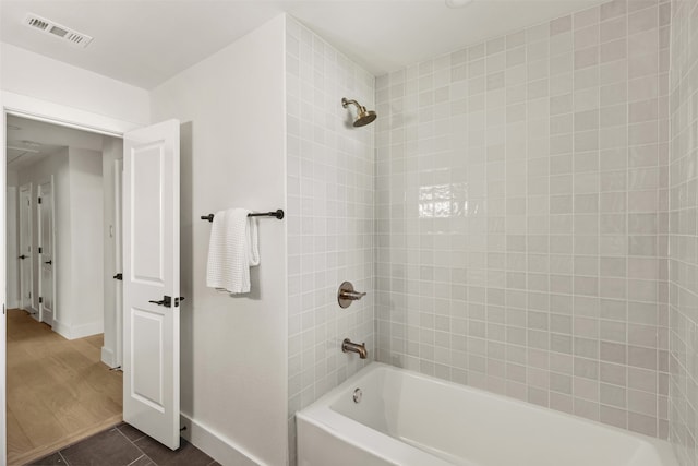 bathroom featuring hardwood / wood-style floors and tiled shower / bath combo