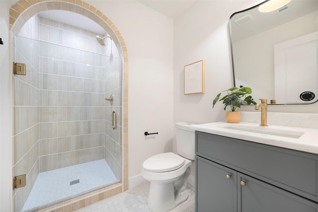 bathroom featuring tile patterned flooring, vanity, toilet, and a shower with door