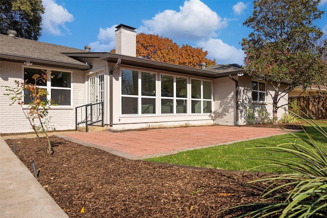 rear view of property with a yard and a patio